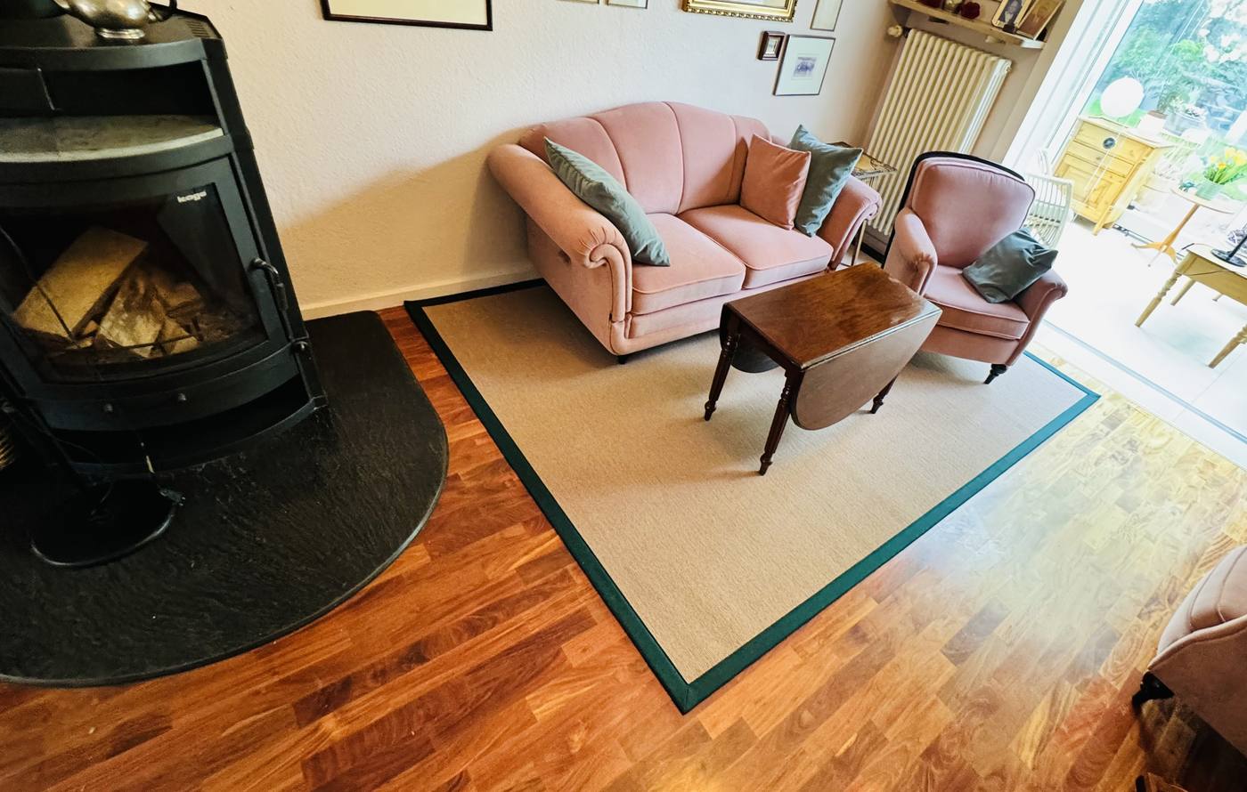 Wohnzimmer mit Kaminofen und Sisalteppich mit dunkelgrüner Einfassung auf Parkett, Dortmund