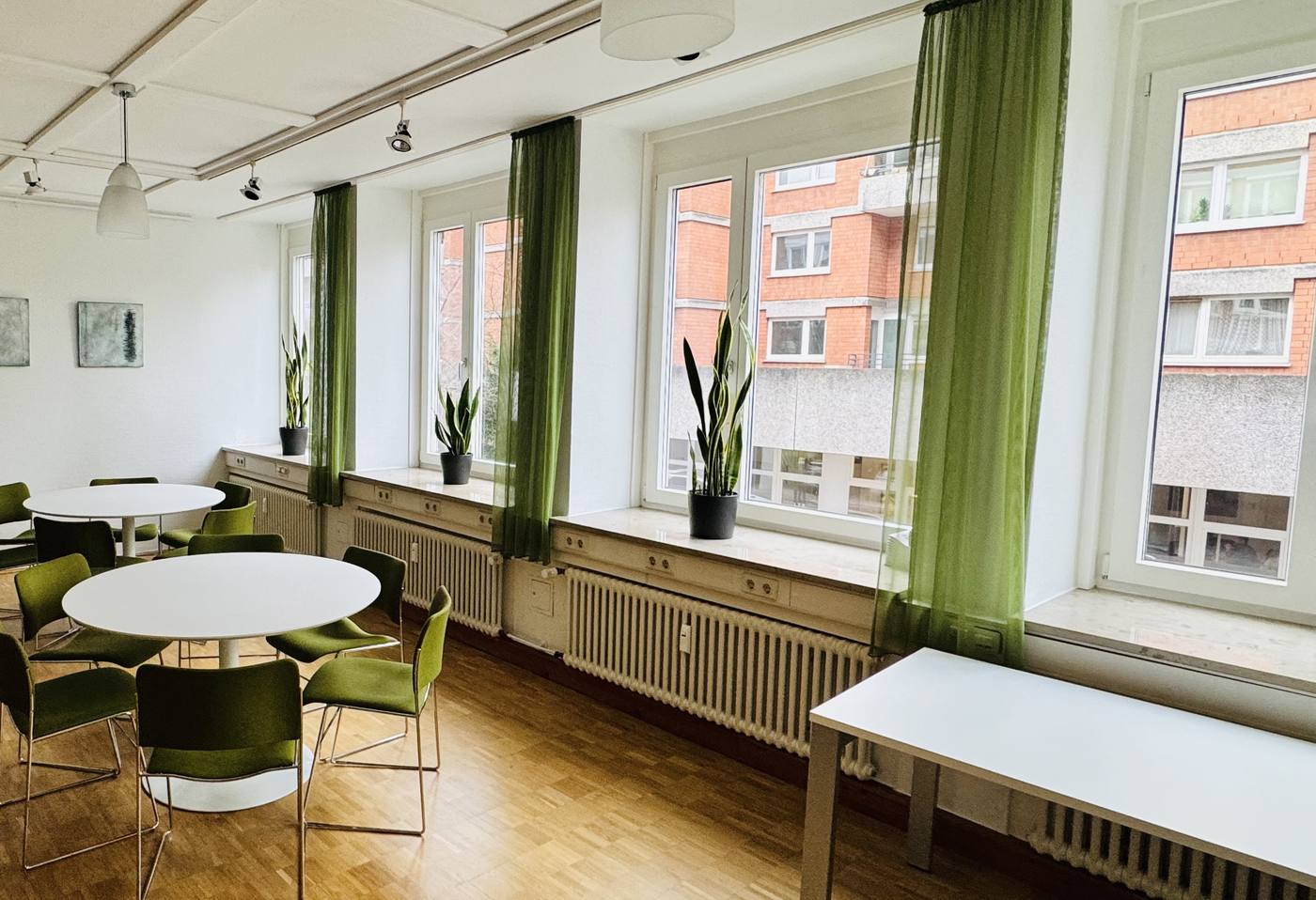 Besprechungsraum mit grünen Vorhängen an einer Fensterfront